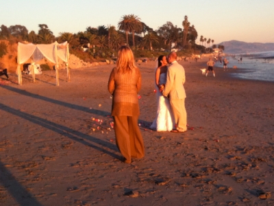 Bride and groom at their sunset beach wedding Canopy on the left photo 